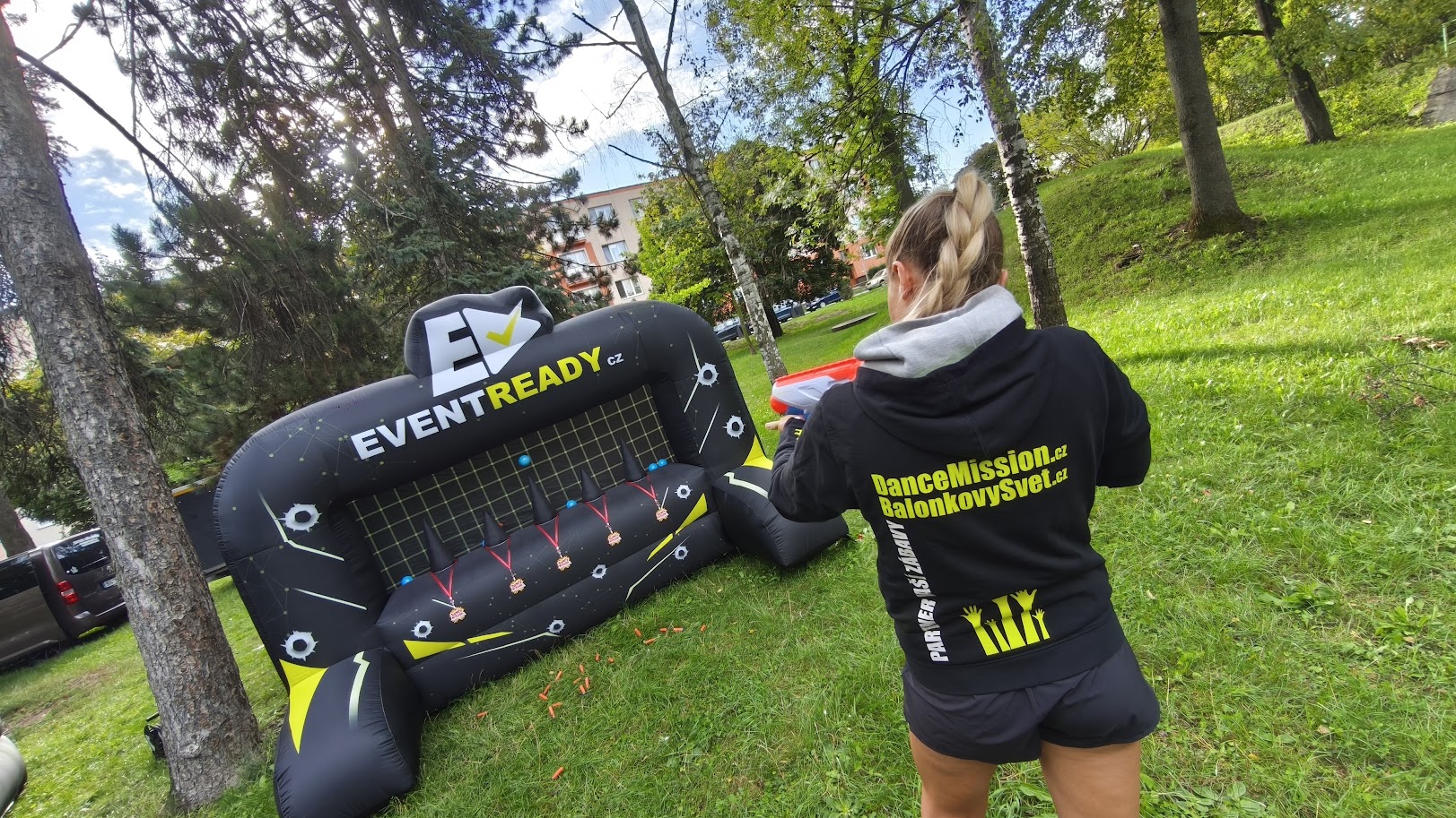 Animátorka DanceMission s nerf blasterem míří na nafukovací terč EventReady