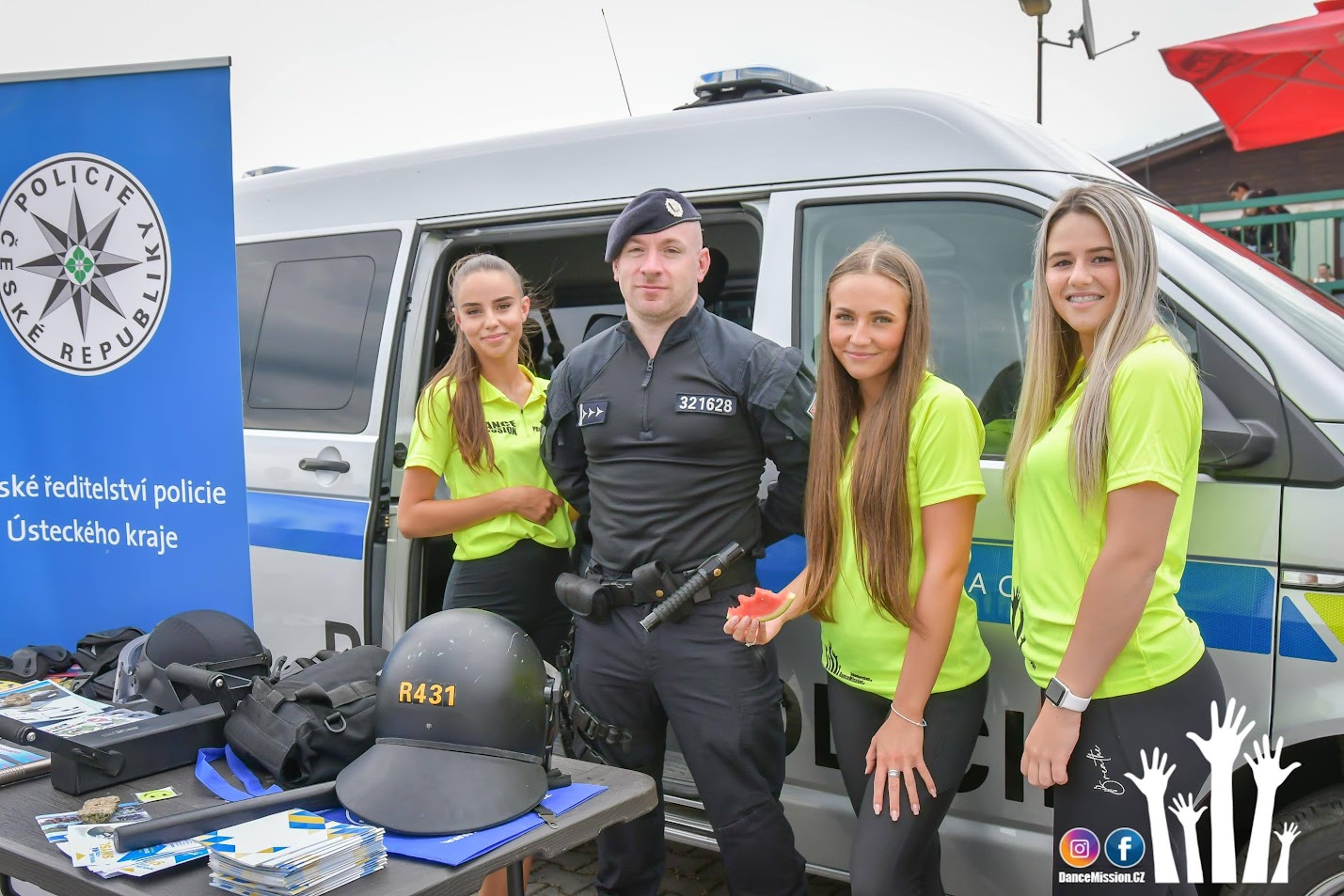 Animátorky DanceMission s policistou u policejního vozu