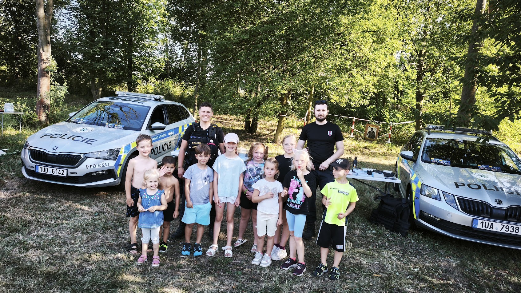 Děti s policisty u policejních vozů na dni prevence v Ledvicích