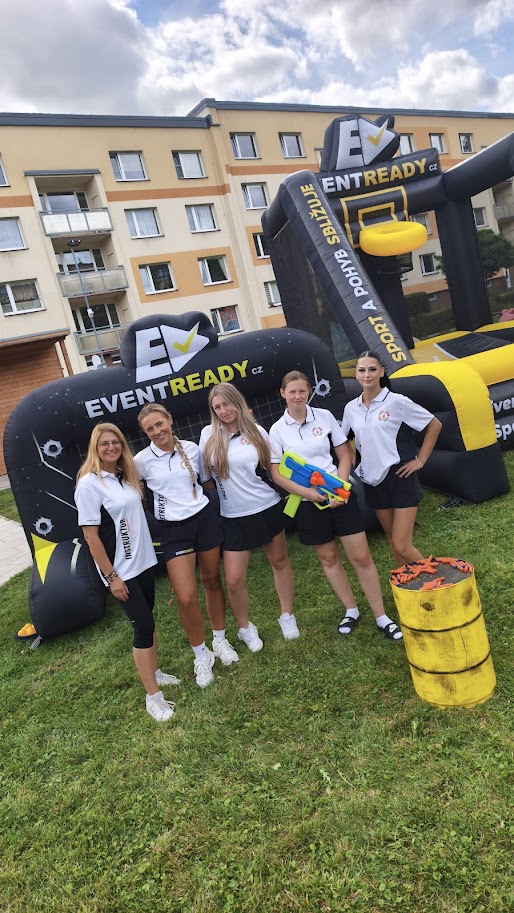 Tým animátorek DanceMission před nafukovacími sportovními atrakcemi EventReady