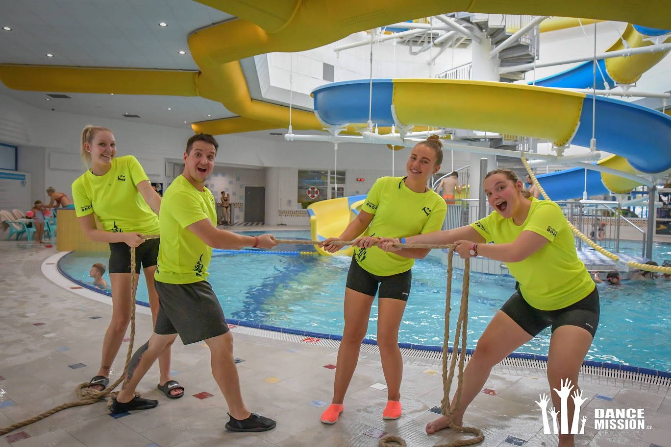 Animační team DanceMission přetahuje lano u tobogánu v aquaparku