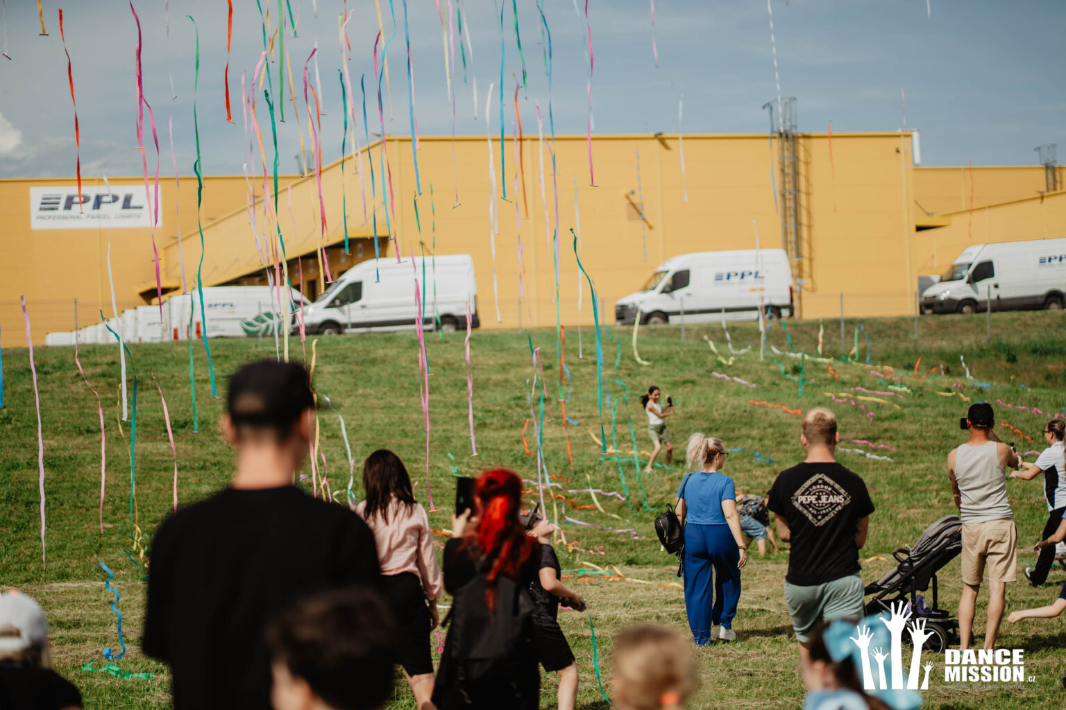 Dav lidí sbírá bonbóny na louce
